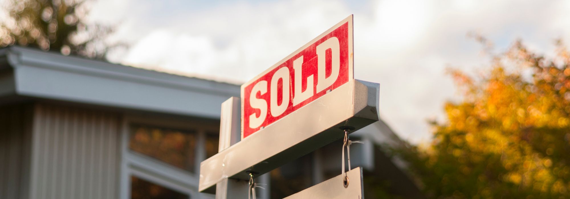 Image of a sold sign in front of a house