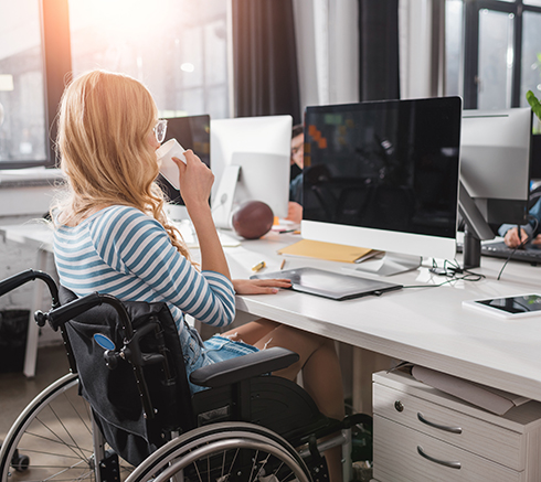 incapacitated person in wheelchair working at modern office