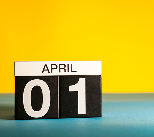 April 1st. Day 1 of april month, calendar on table with yellow background. Spring time, empty space for text