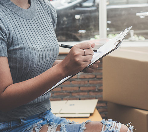 woman checking stuff in cardboard box before sent to transportat