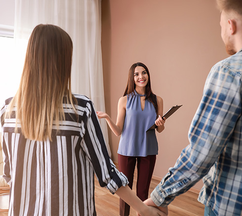 Real estate agent showing young couple a new house