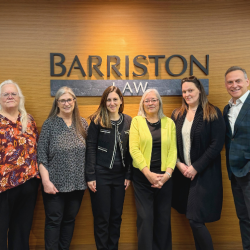 Photo of the Alousis Law team in front of the Barriston Law logo