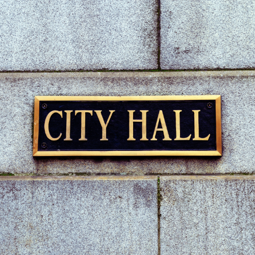 Close up photo of a plaque on a building that says City Hall