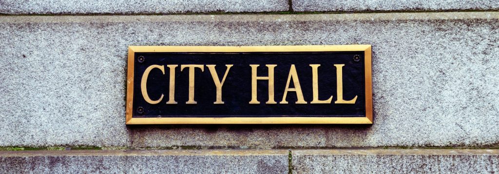 Close up photo of a plaque on a building that says City Hall