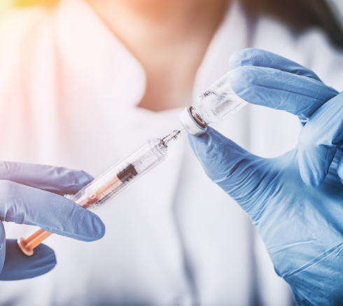 Health care working with a vaccine syringe