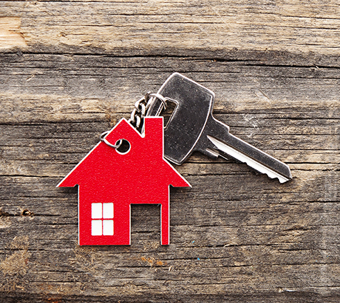 Symbol of the house with silver key on vintage wooden background